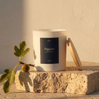 Bougie parfumée Figuier JLT avec branche de figuier et lumière chaude de fin de journée dans une ambiance méditerranéenne épurée.