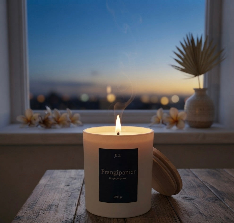 Bougie parfumée Frangipanier JLT 220 g allumée dans une ambiance douce au coucher du soleil