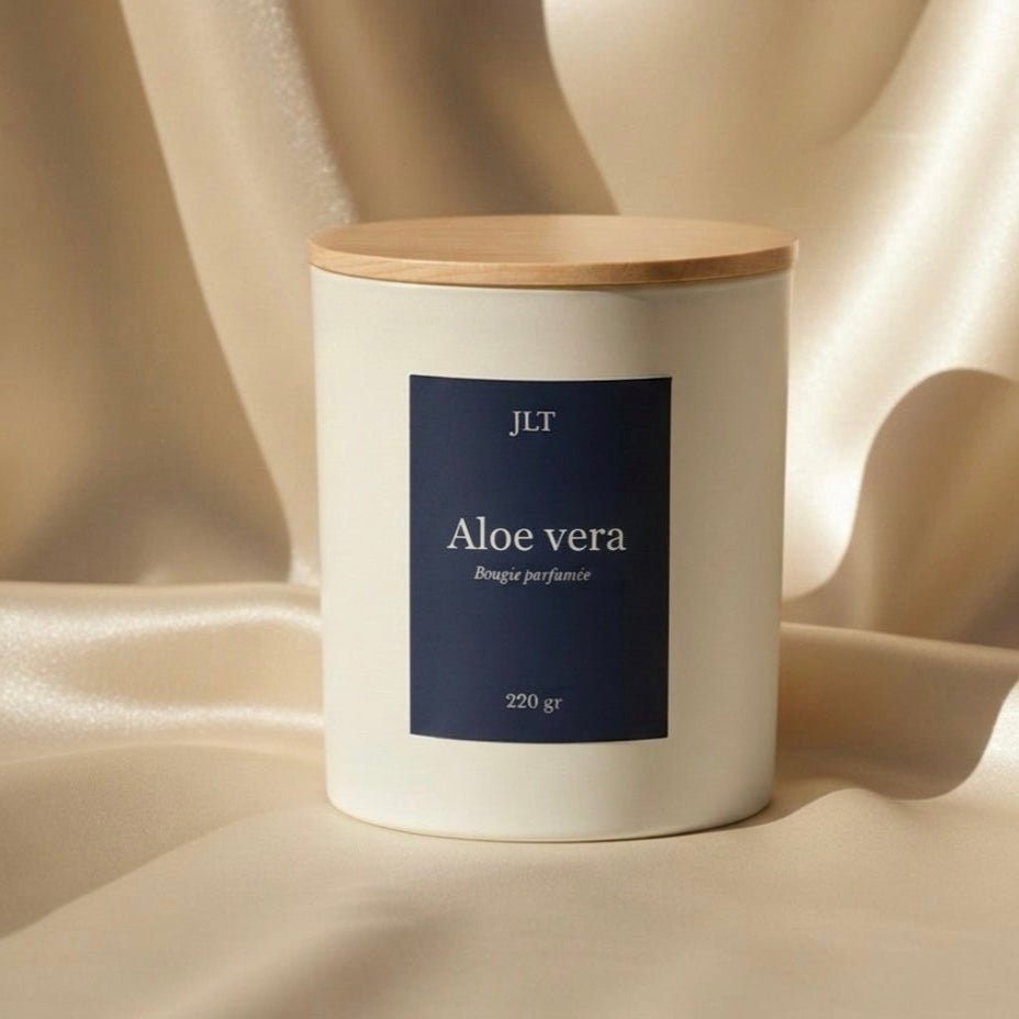 Bougie parfumée Aloe vera JLT posée sur un tissu satiné beige, ambiance douce et élégante, décoration intérieure minimaliste