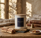 Bougie parfumée Bois chaud JLT 220 g présentée avec des bois et matières naturelles