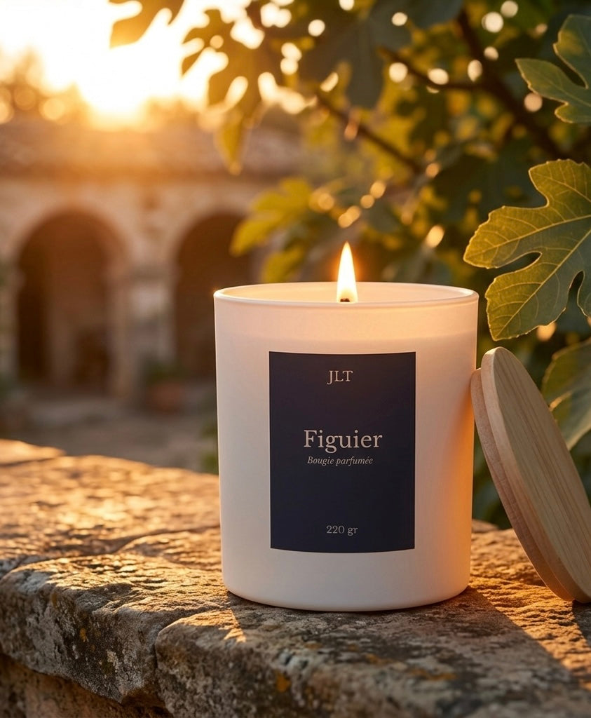 Bougie parfumée Figuier JLT 220 g allumée dans une lumière dorée au coucher du soleil