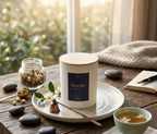 Bougie parfumée Pure thé JLT 220 g dans une ambiance calme avec tasse de thé et carnet