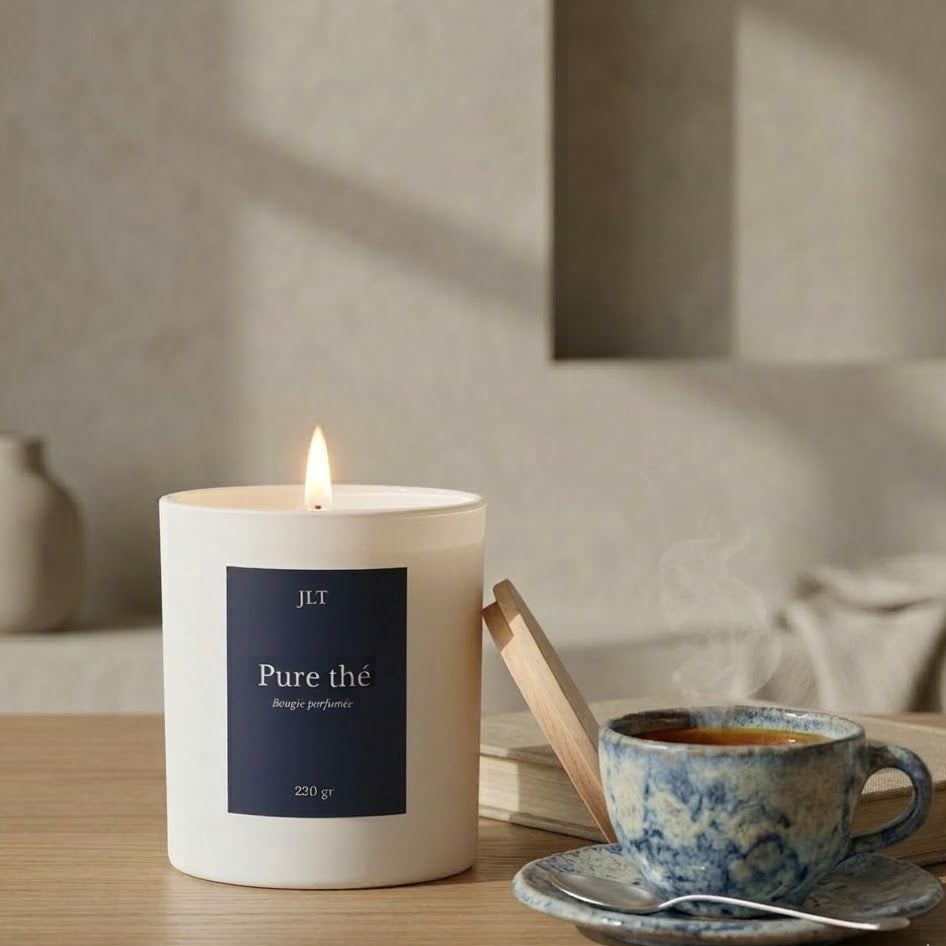 Bougie parfumée Pure thé JLT Bougies 220g allumée sur une table avec tasse de thé dans une ambiance douce et apaisante