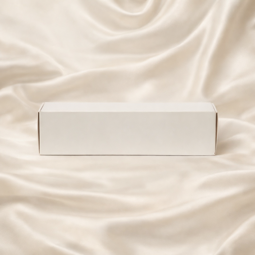 Coffret de fondants parfumés JLT fermé présenté sur un drap de soie ivoire