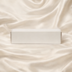 Coffret de fondants parfumés JLT fermé présenté sur un drap de soie ivoire