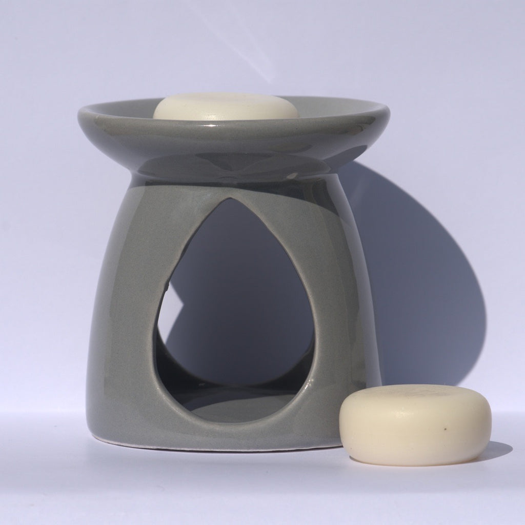Fondant parfumé JLT posé dans un brûle-parfum gris, utilisé pour diffuser le parfum dans la maison